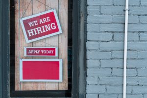 Sign in shop window saying we are hiring